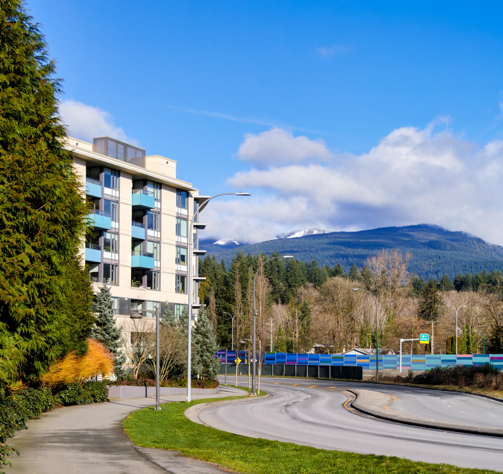 Cityscape with residential building and road curve around on blue sky background