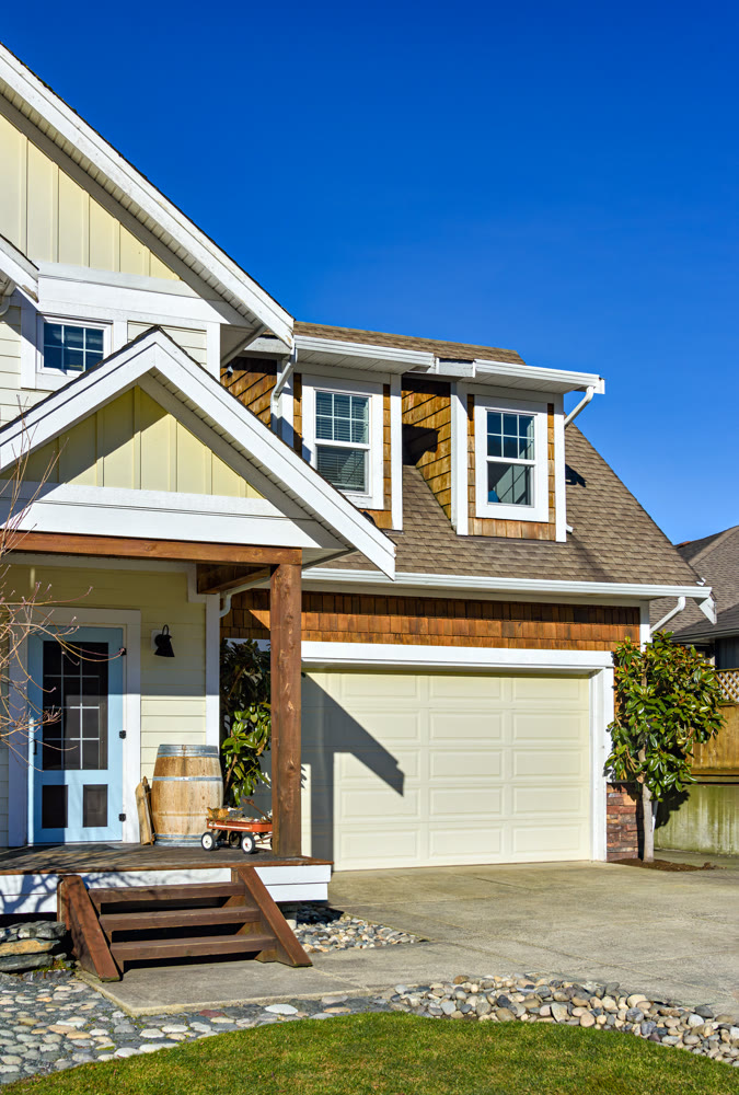 Entrance of residential house with green lawn on the front yard on blue sky background
