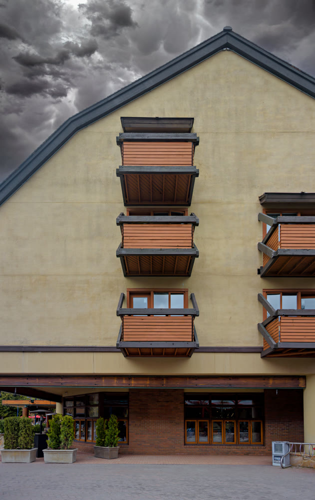 Residential building with balconies on stormy sky background
