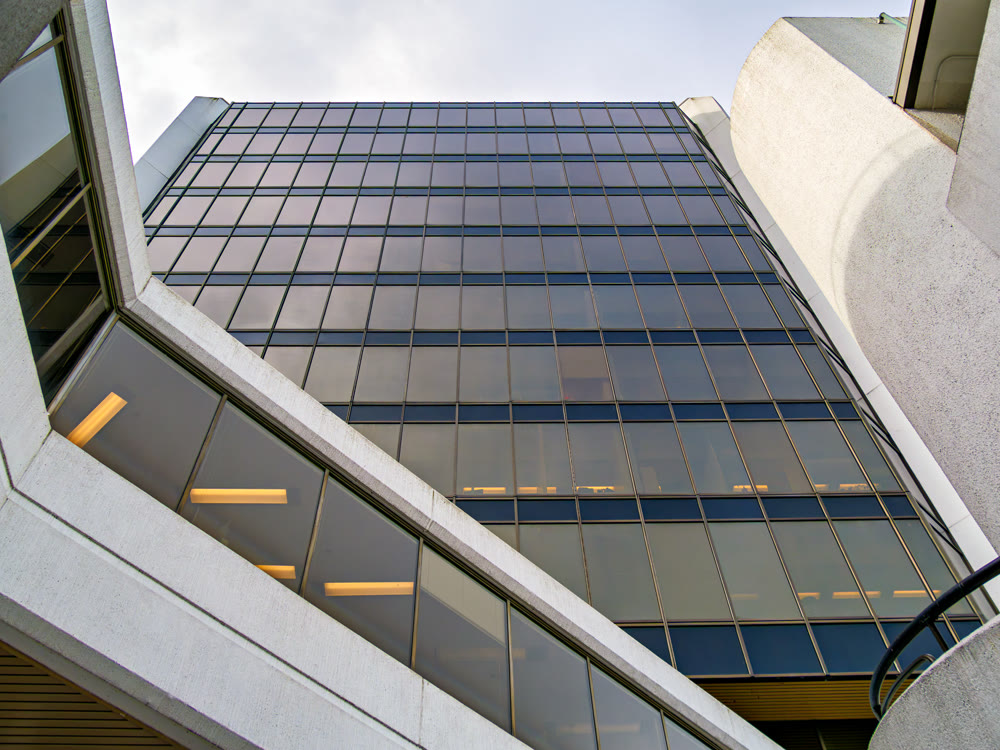Modern glass office building facade with concrete angular structures