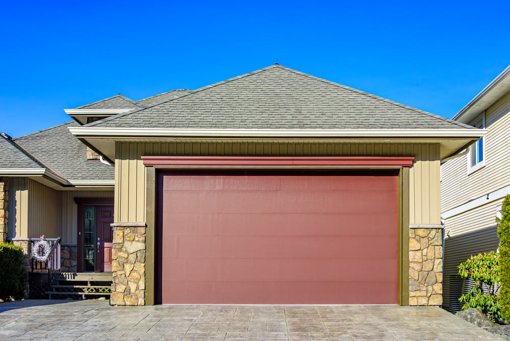 Modern suburban house exterior featuring a wide red double garage door
