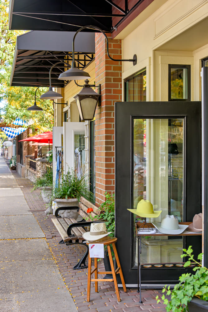 Title.Storefront Entrance with Hats on Display Along a Town Sidewalk