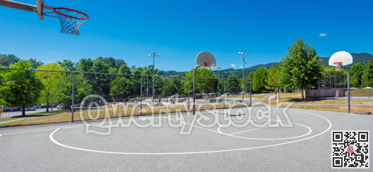 Playground with basketball court in a park on a bright sunny day