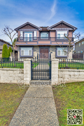 Big residential house with metal fence and gate on winter day