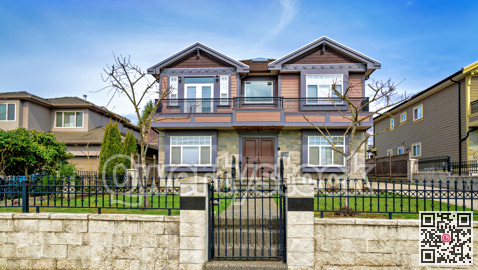 Big residential house with metal fence and gate on winter day
