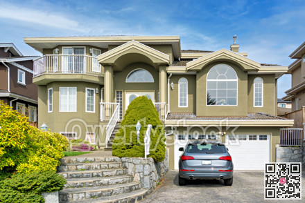 Luxury residential house with a car parked in front on cloudy day