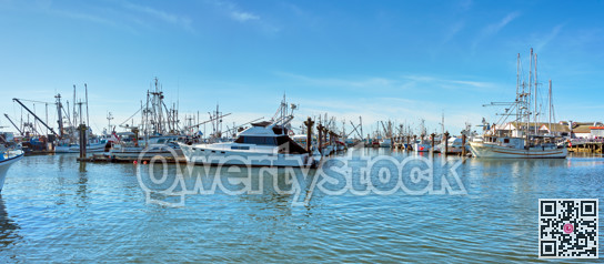 Small fishing trawler and yachts moored at the ocean pier