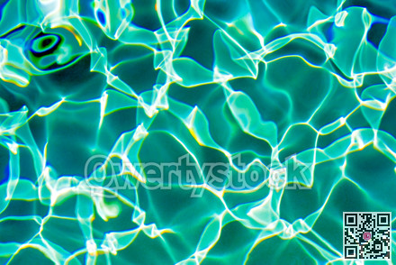 Sunflecks on emerald water surface in a swiming pool