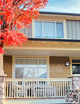 Front patio and top level of residential house with red maple tree in front