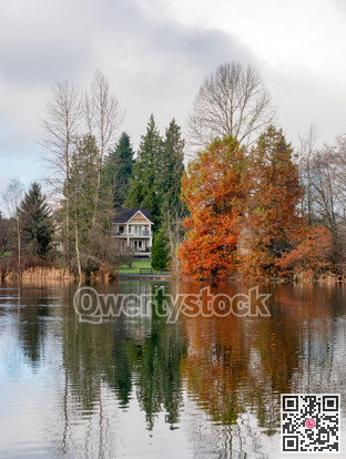 Autumn landscape featuring a house by the lake
