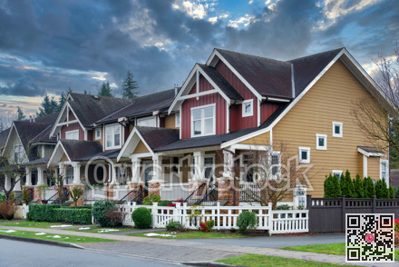 Street of residential townhouses on stormy sky background