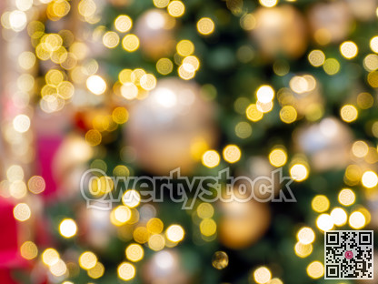 Yellow gold holiday lights on blur Christmas tree background