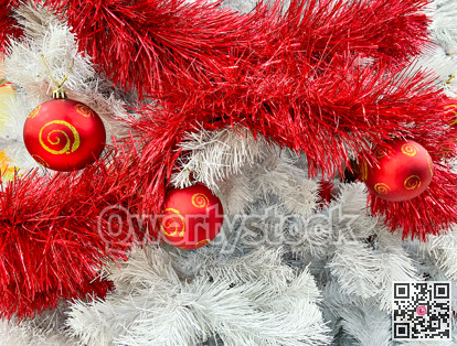 Red baubles with golden ornament on pine tree brenches