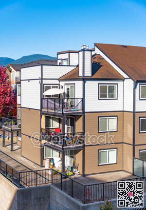 Corner of three storey apartment building on sunny day