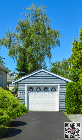 Stand along single garage on a back yard with asphalt driveway.