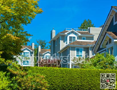 Top of residential townhouses on blue sky background.