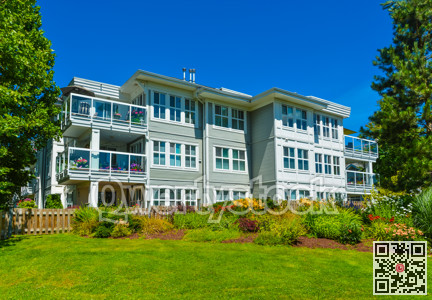 Luxury apartment building with green lawn in front