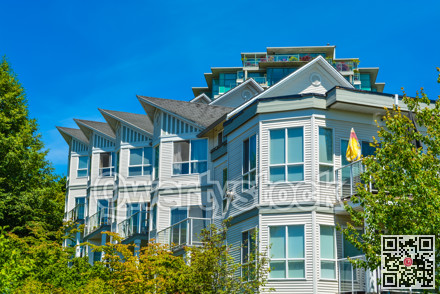 Top of luxury apartment building with green trees surround.