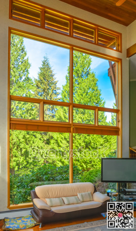 Leather couch and TV set in front of huge window in living room