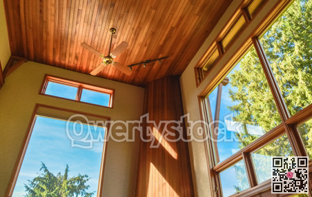 Stained glass windows in spacious living room with ceiling decorated in wood