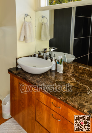 Hands wash basin at the mirror in a bathroom of luxury house.