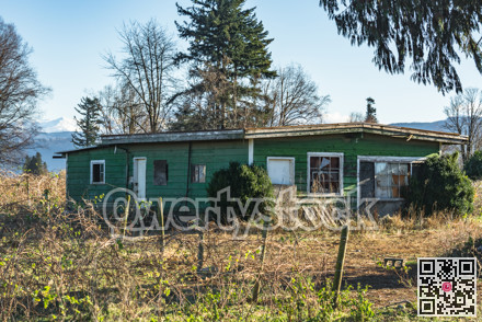 Old abandoned house in disrepair on cold fall day.