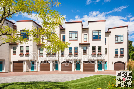 Residential townhouses with decorative acacia tree in front