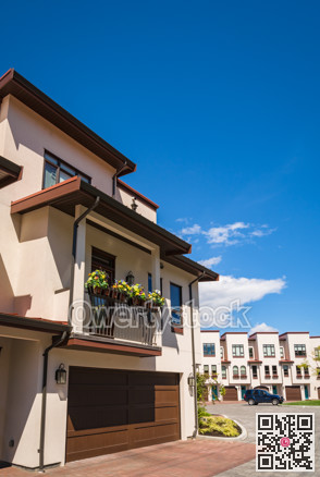 Residential townhouses with paved driveway on blue sky background on sunny day