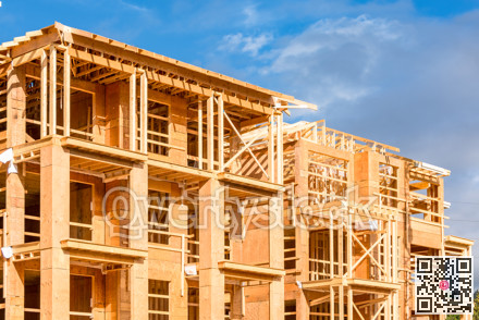 Apartment building under construction on sunny day on blue sky background.