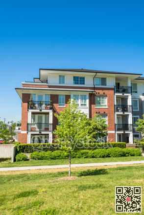 New low rise apartment building with concrete pathway and small tree in front