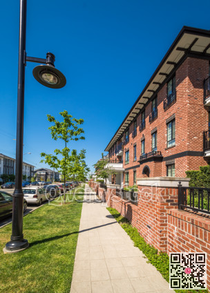 Paved ramp to the entrance of new apartment building on sunny day with blue sky