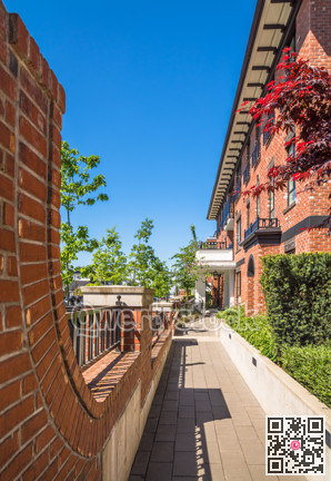 Paved ramp to the entrance of new apartment building on sunny day with blue sky.