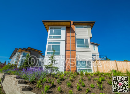 Brand new townhouse building on the hill with landscaped slope on sunny day