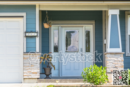 White door of residential house with dome shaped window and flower pots outside.