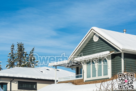 Top of residential house in snow on sunny winter day in Canada.