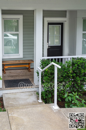 Entrance porch of residential unit with wooden bench at the door.