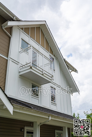 Top of townhouse building on cloudy sky background.