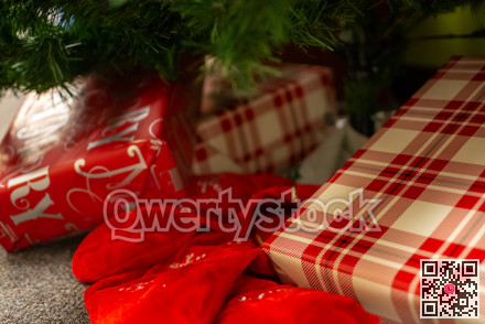 Christmas gifts laying underneath of fir tree branches.