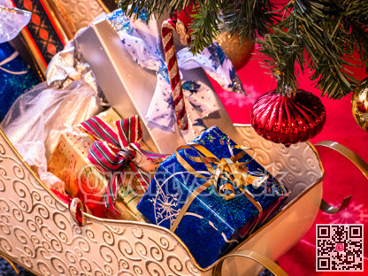 Decorative Santa Claus sleigh with coloured gifts boxes under Christmas tree.