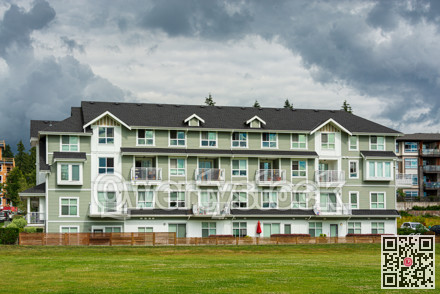 New residential low-rise building on cloudy sky background