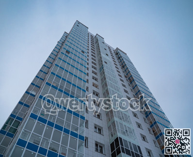 New highrise residential tower on blue sky background.