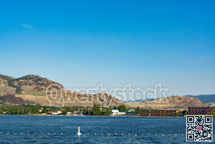 Resorts on Osoyoos lake shore with blue sky and mountain background