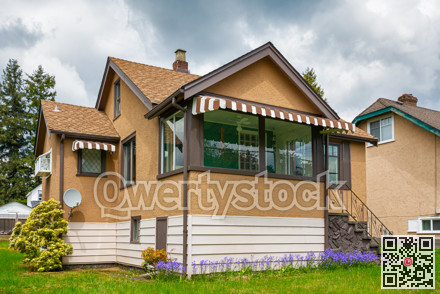 Modest family house with green lawn in front. Old residential house