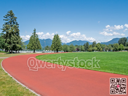 Red jogging track of recreational stadium on bright sunny day