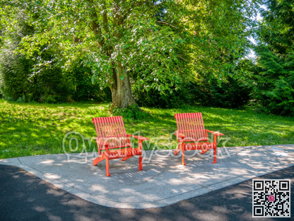 Recreational area in a park with two red chairs under the tree