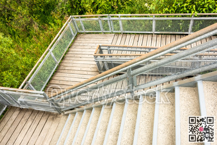 Stair and wooden deck with metal rails in a park