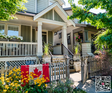 Porch and entrance of residential house with canadian flag on the fence in front