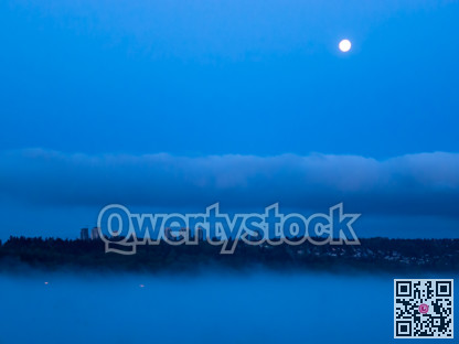 Cityscape in the night with full moon over in the sky