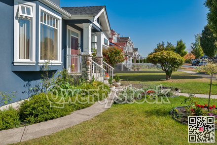 Front yard of family houses along the street on sunny day
