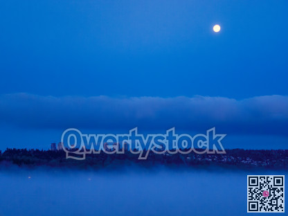 City in the night with full moon over in the sky